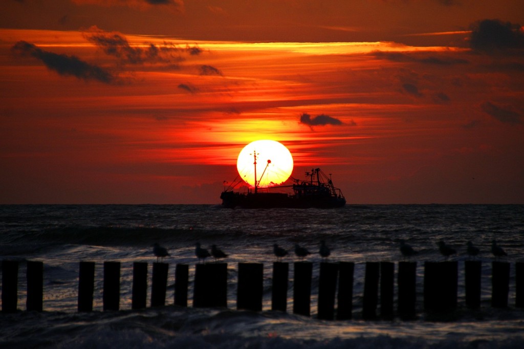 Schiff bei rotem Sonnenuntergang auf dem Meer